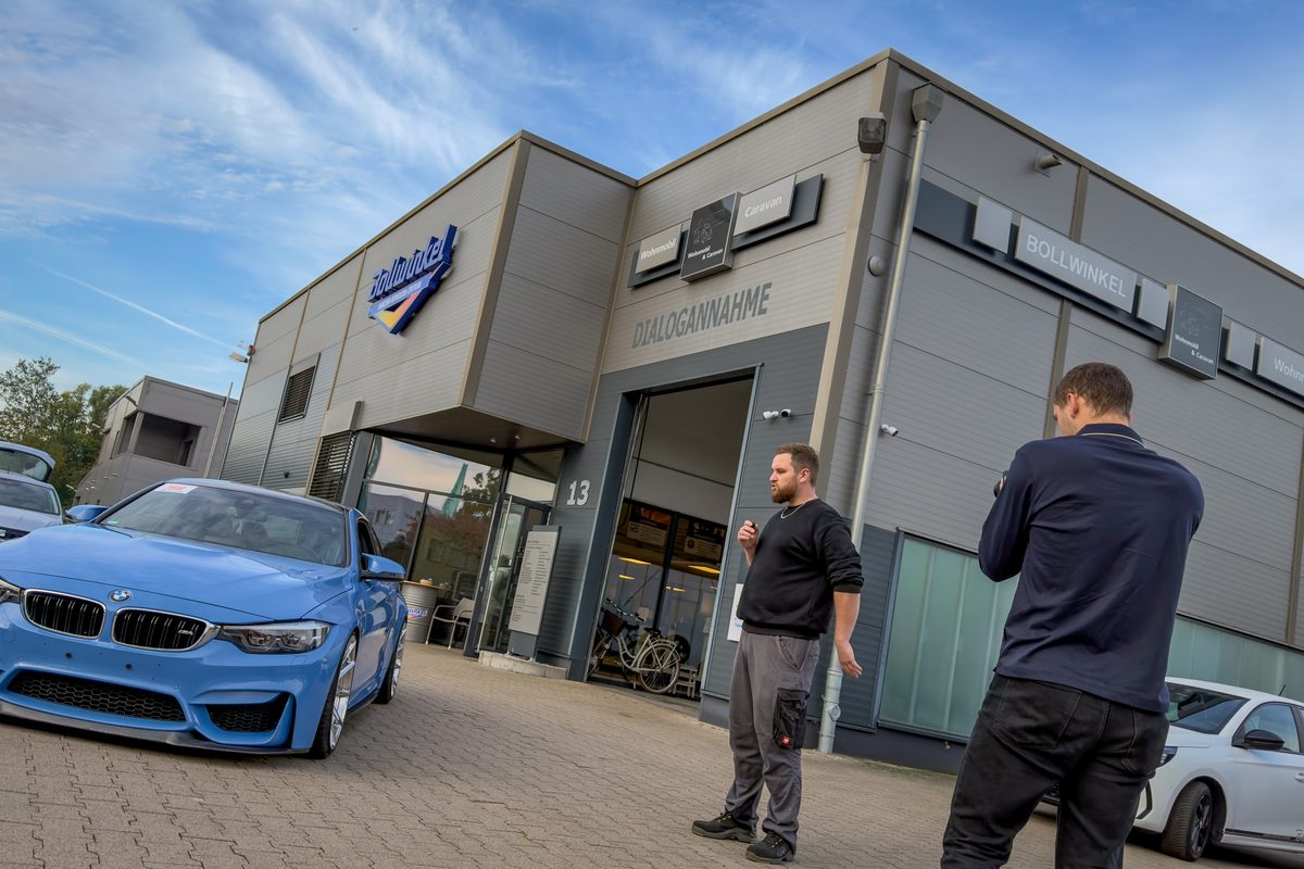 Videodreh vor dem Fahrzeug-Reparatur-Zentrum Bollwinkel in Bremen, davor ein blauer BMW M4