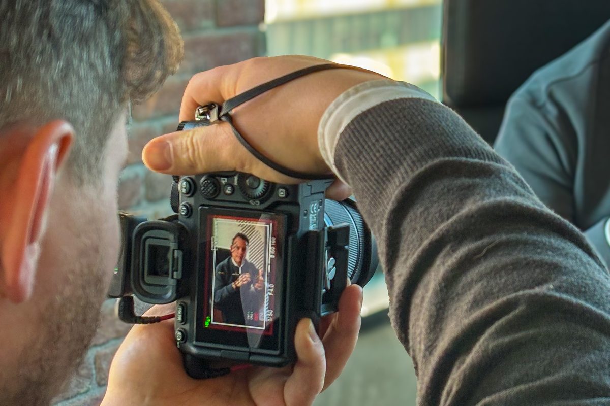 Fotograf von Green Media Bremen prüft ein Porträtfoto auf dem Kameradisplay im Studio