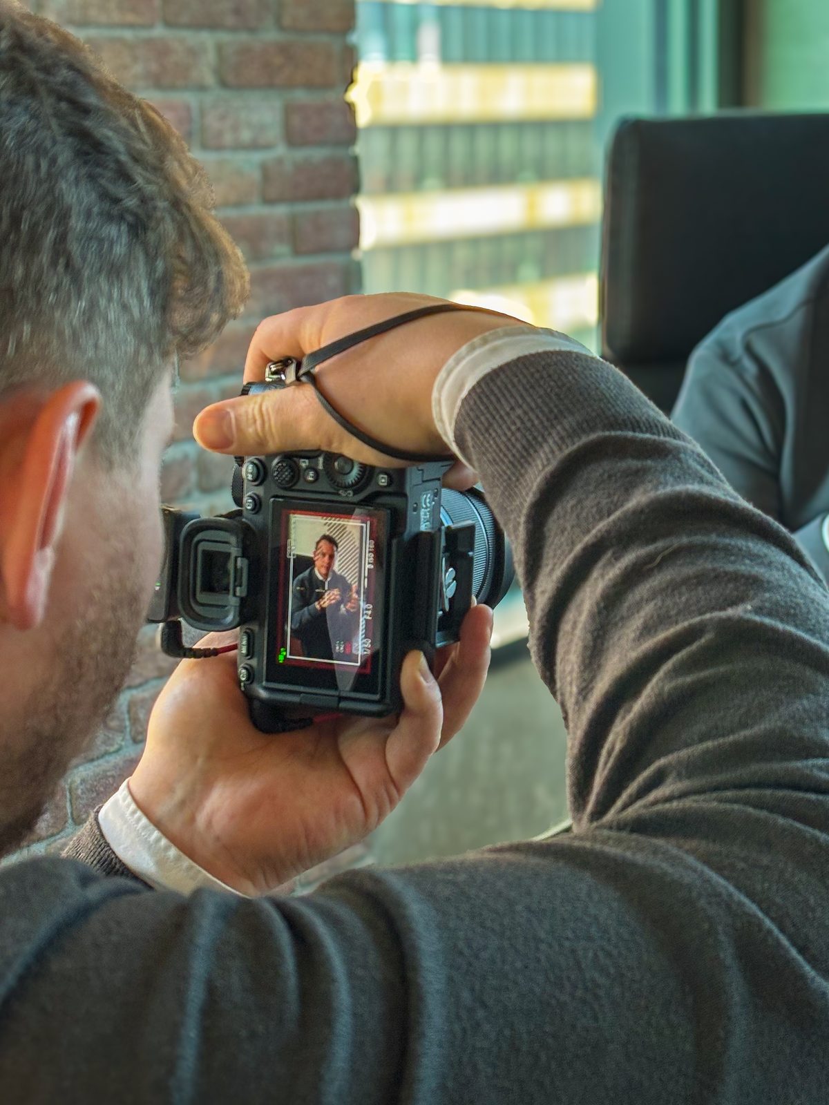 Fotograf von Green Media Bremen prüft ein Porträtfoto für ein LinkedIn-Profil auf dem Kameradisplay