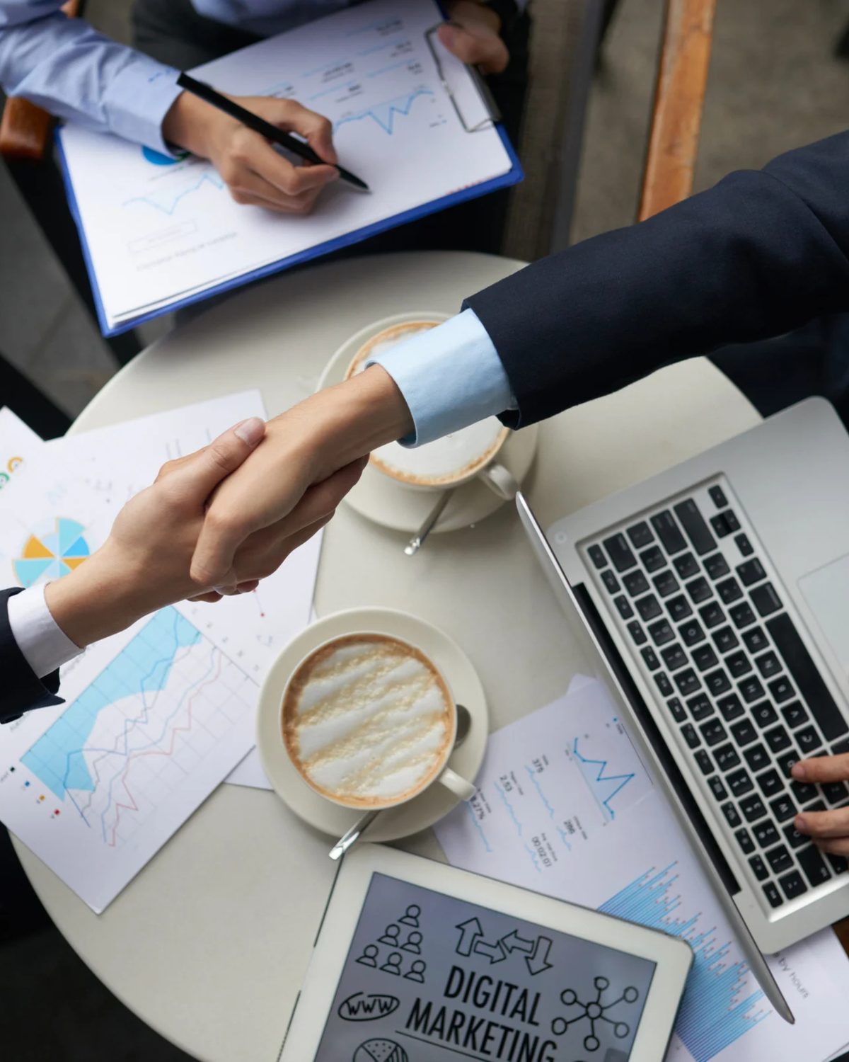 Handschlag zwischen Kunde und Marketingagentur in Bremen über Unterlagen zur Marketingplanung