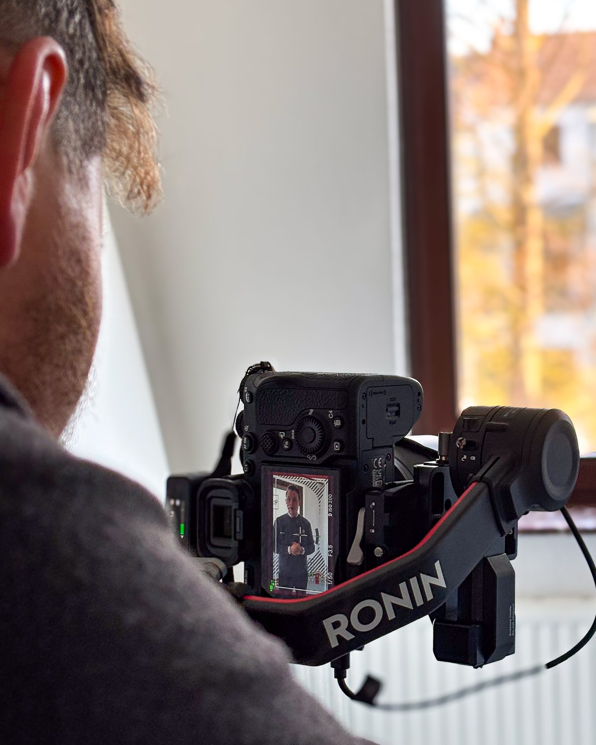 Immobilienvideo in Bremen: Kameramann filmt mit Gimbal einen Makler in einer leeren Altbauwohnung