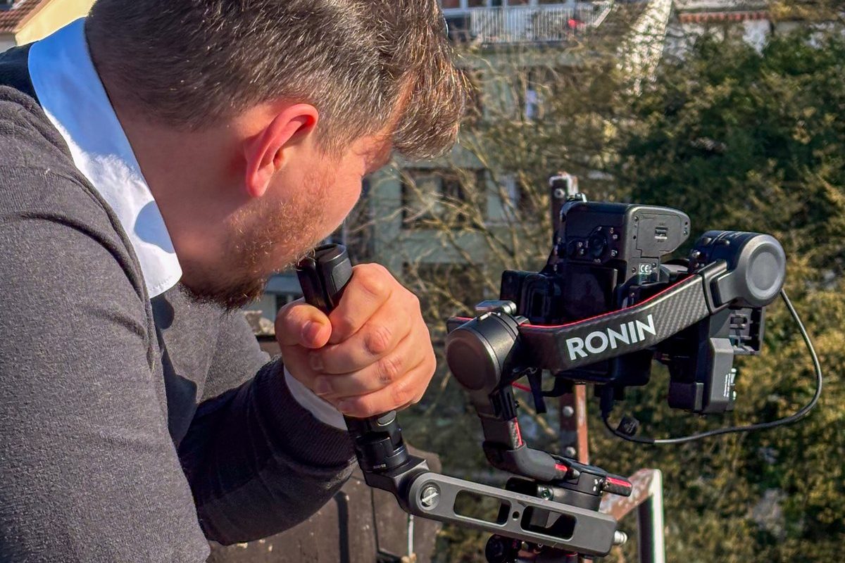 Kameramann von Green Media Bremen filmt mit Gimbal-Kamera auf einem Dach über Bremen