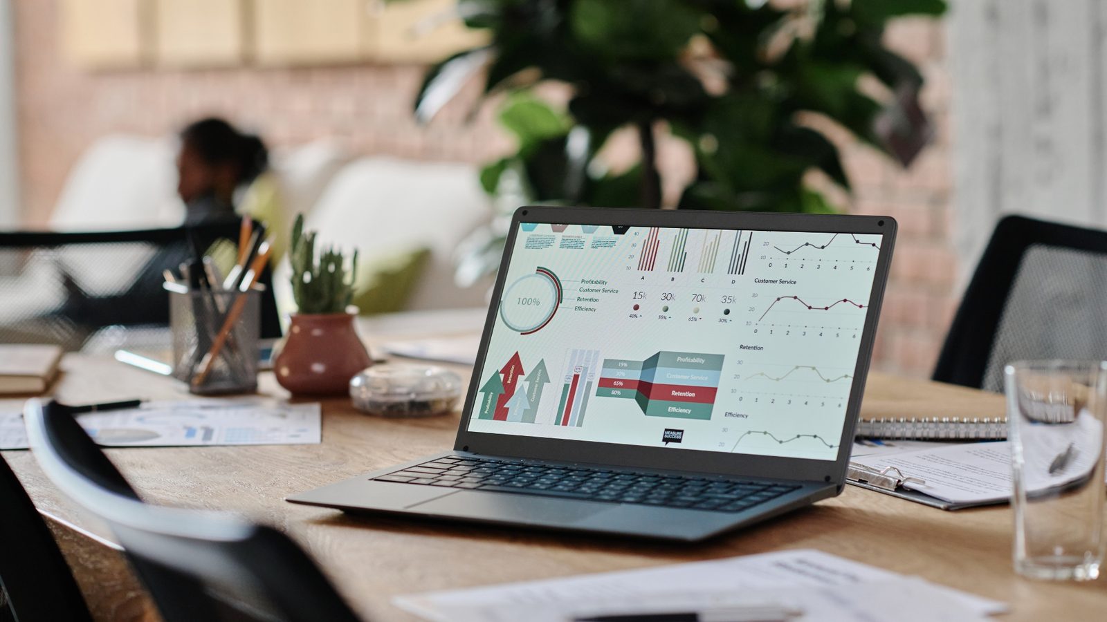 Laptop mit Diagrammen zur Kostenauswertung auf einem Schreibtisch im Büro