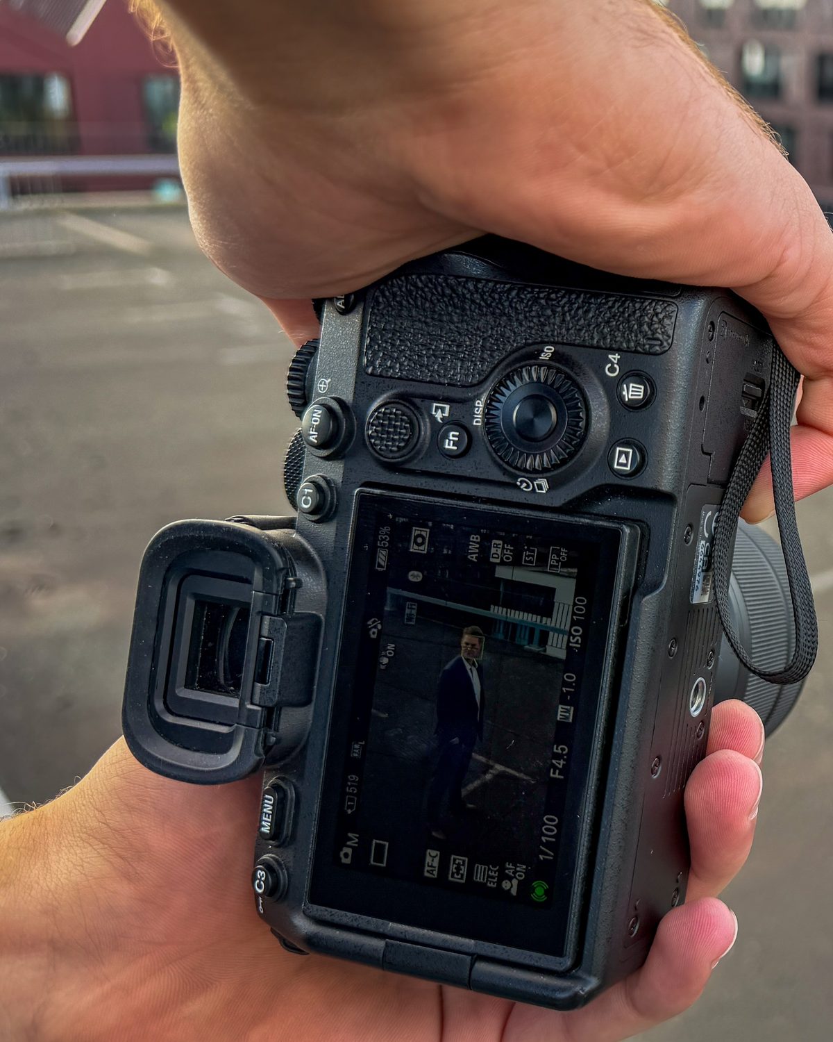 Kamera in der Hand des Fotografen beim Personal-Branding-Shooting auf einer Dachterrasse