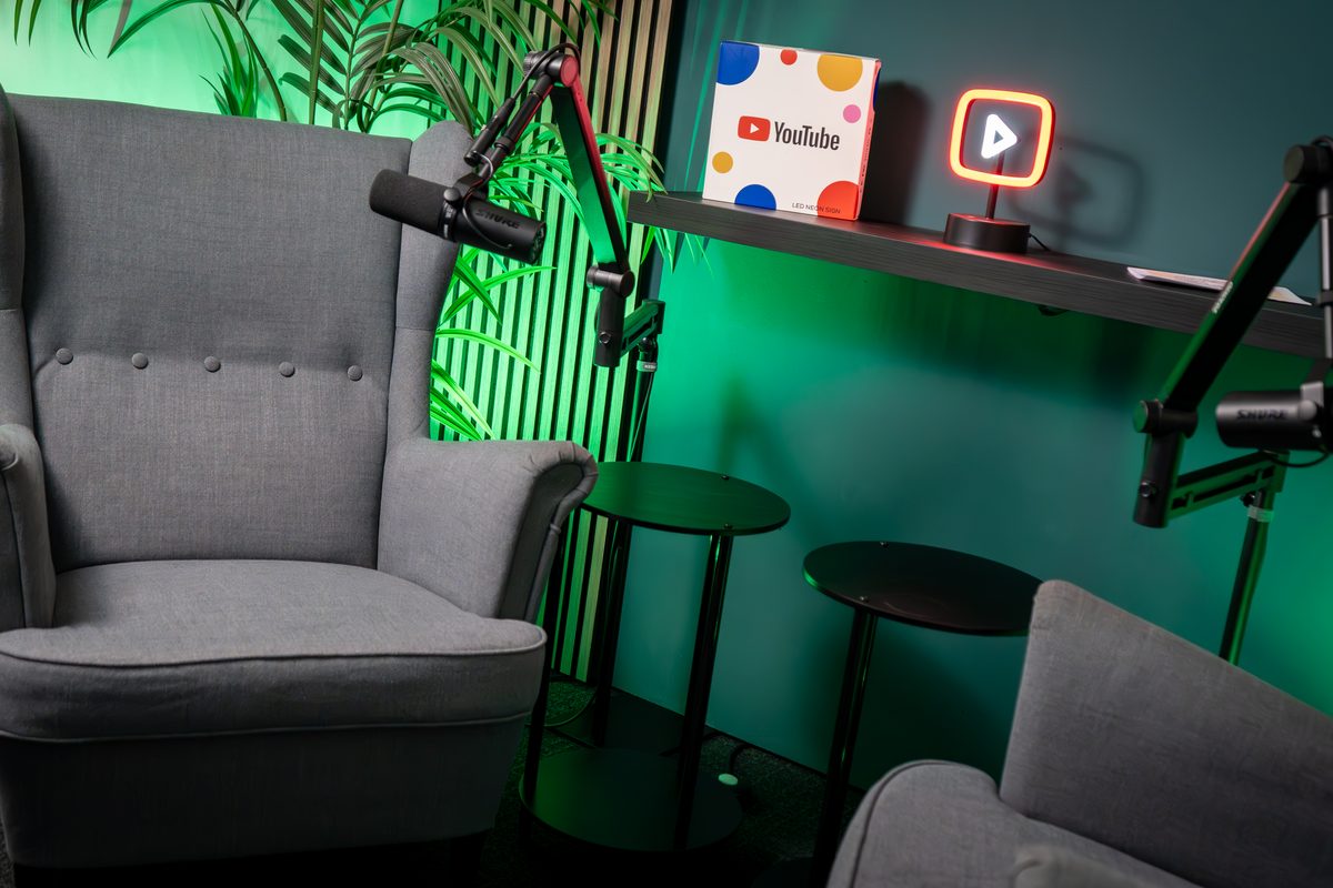 Podcast-Studio von Green Media Bremen mit Sesseln, Mikrofonen und grünem Licht