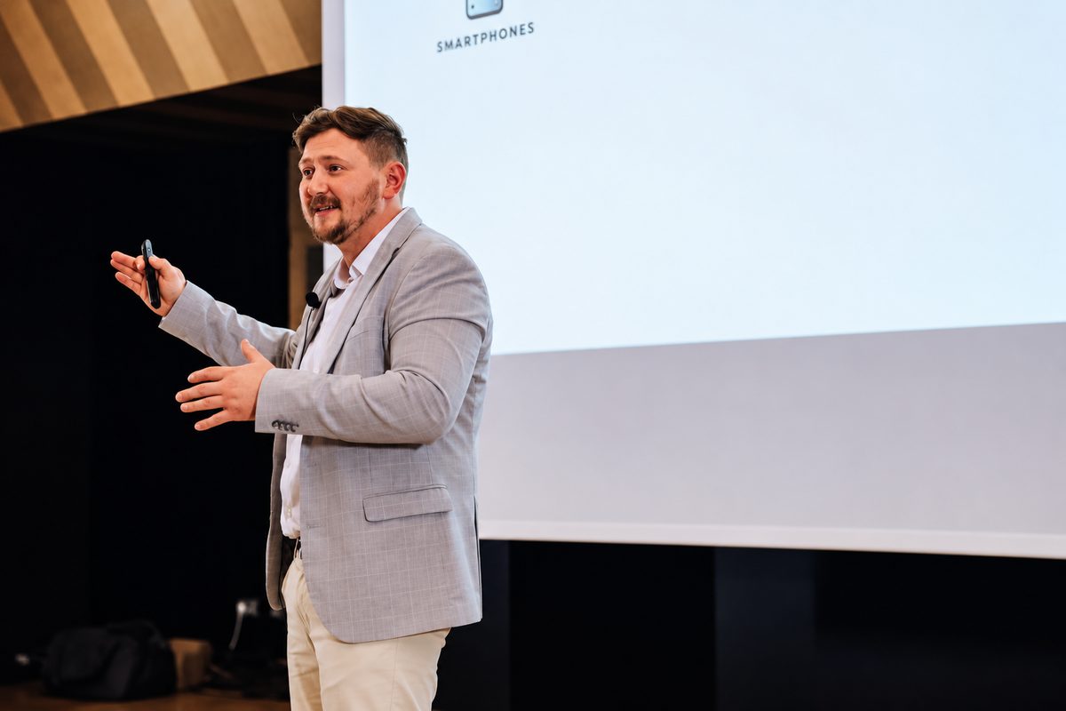 Andreas Efremov von Green Media Bremen spricht auf einer Bühne vor einer Präsentationsleinwand